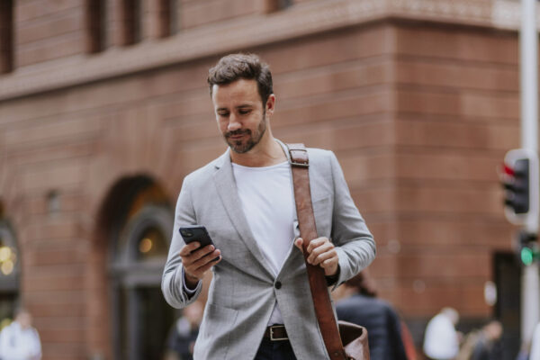 Trendy man checks his messages on his way to his office