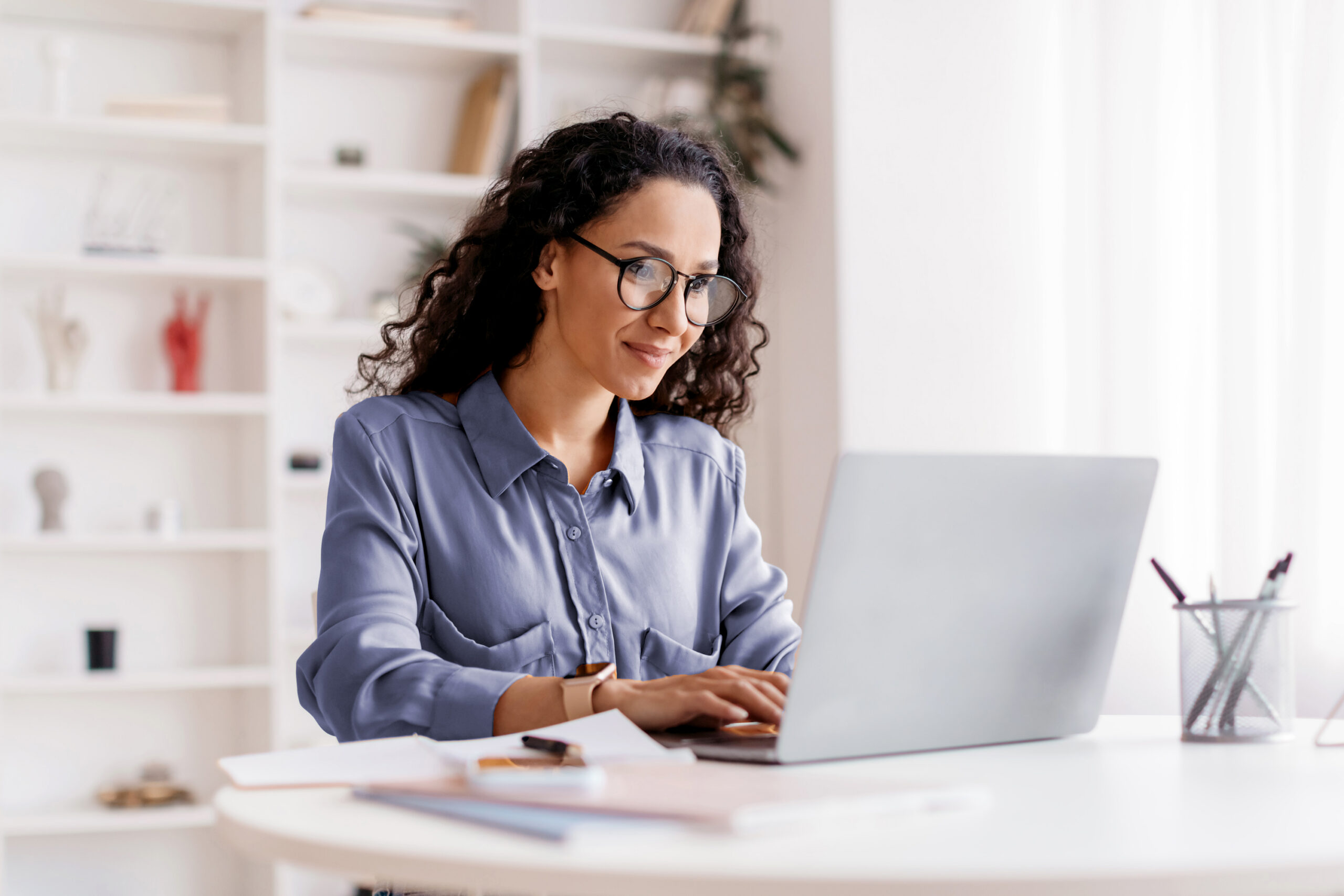 Woman smiling at computer screen while working from home