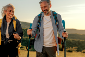 Middle-aged couple hiking happily together at sunset