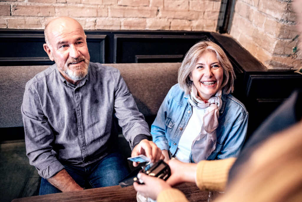 Older couple purchasing something with a credit card