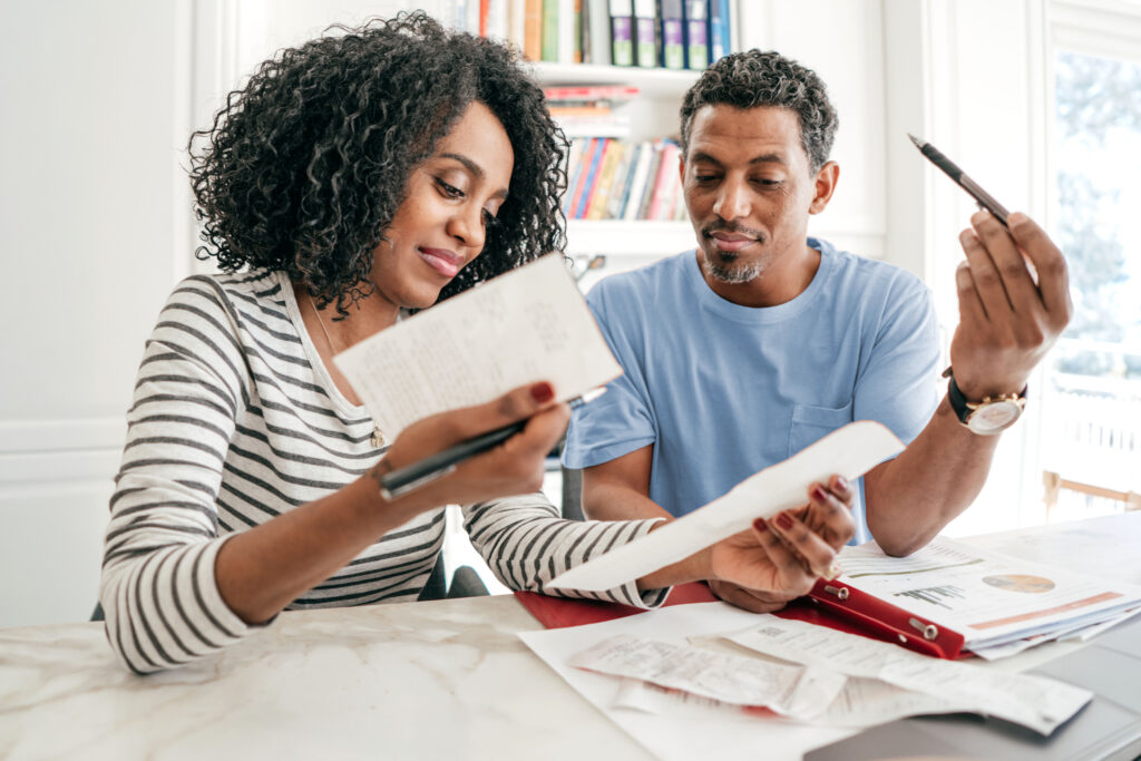Man and woman in their 40's looking over their monthly budget and retirement plans