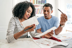 Man and woman in their 40's looking over their monthly budget and retirement plans