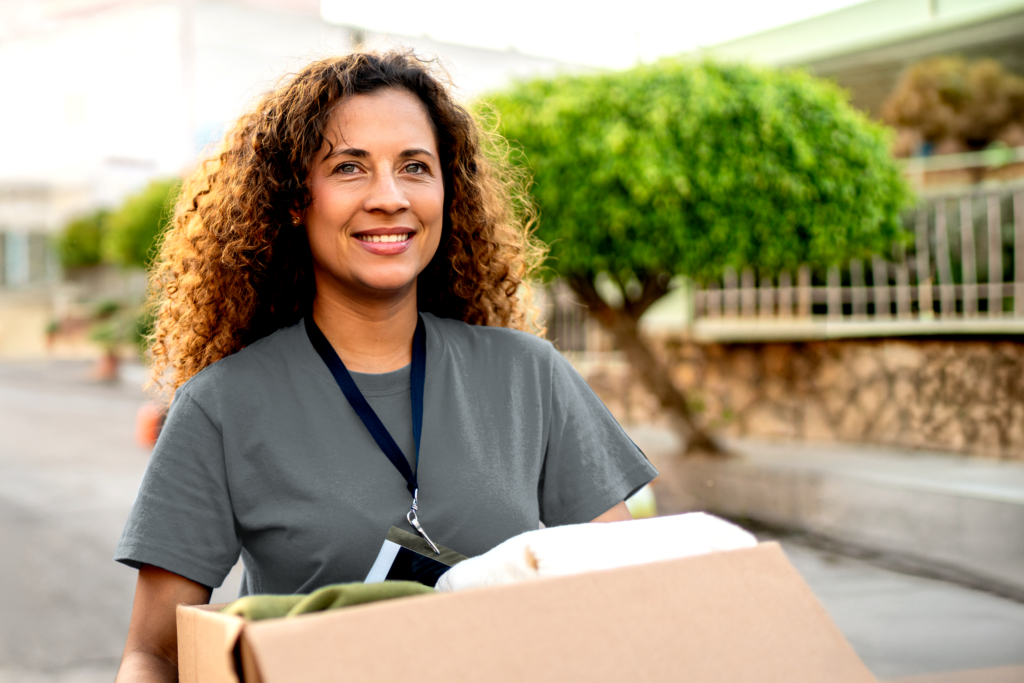 Woman happily carrying a box of donations to charity